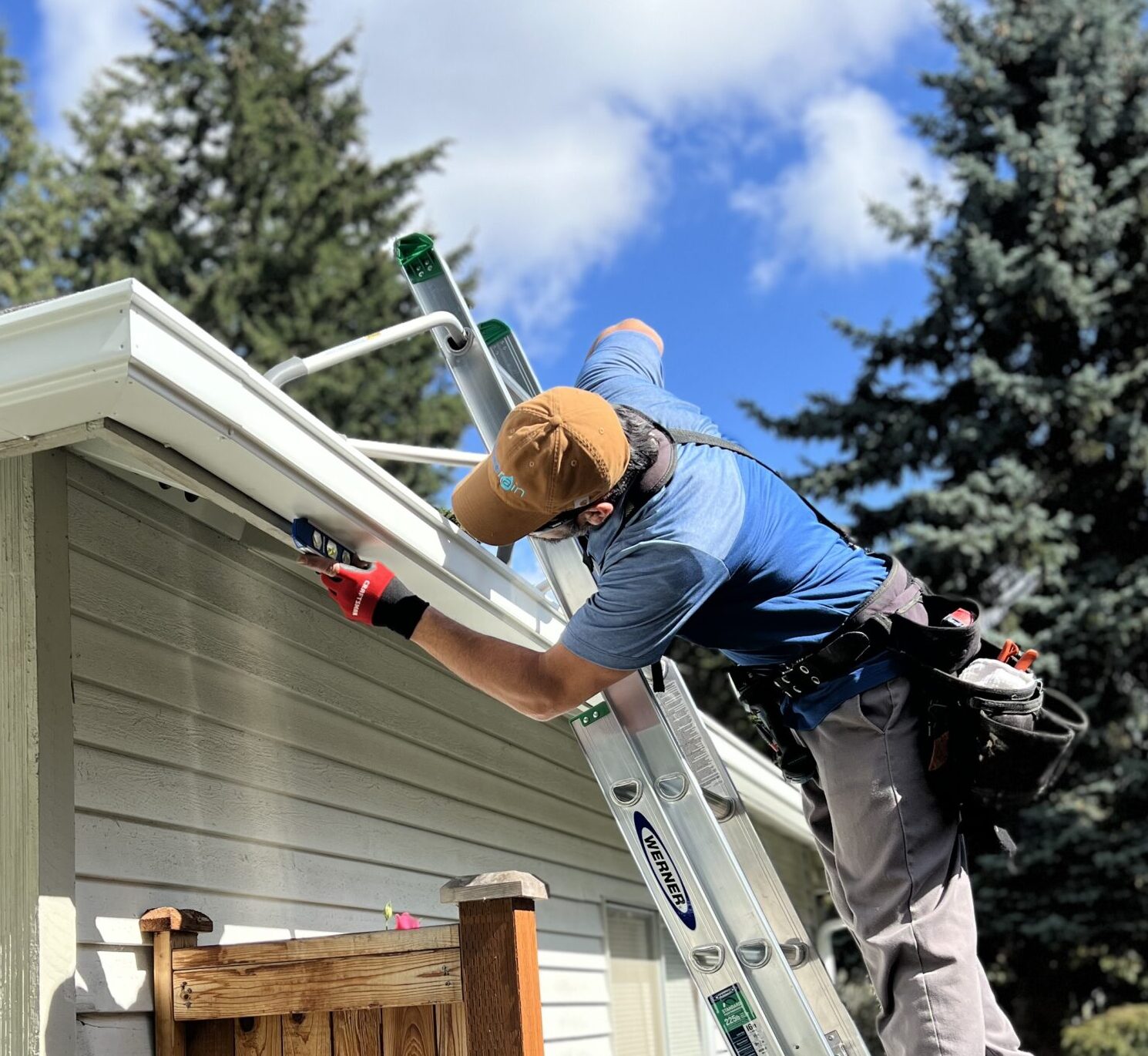 An image of a FreeRain employee installing a new FreeRain gutter system on the home.